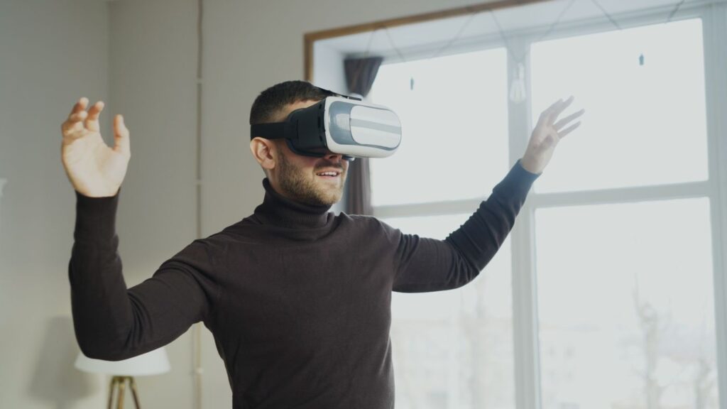 Man wearing a VR headset with arms raised while playing a game