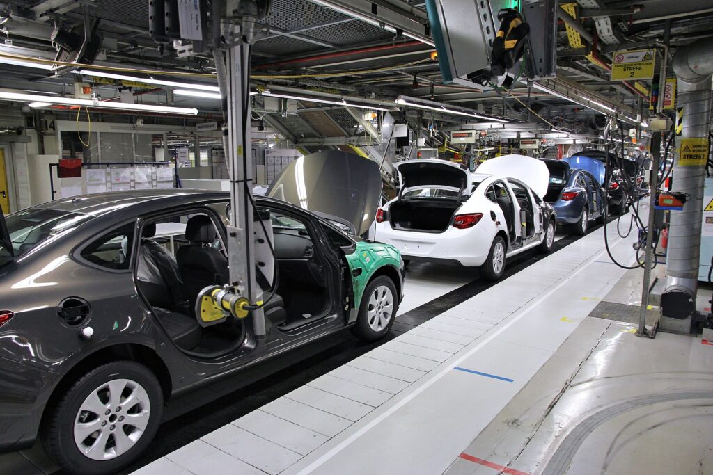Battery Recycling Becomes the EV Industry’s Second Mine Workers and robots on a car factory assembly line building new vehicles